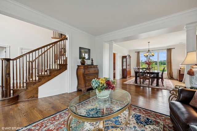 living area with a chandelier, wood finished floors, and decorative columns