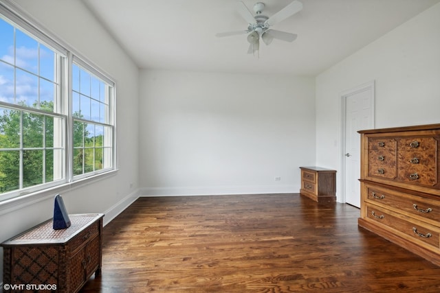 interior space featuring ceiling fan, baseboards, and dark wood finished floors