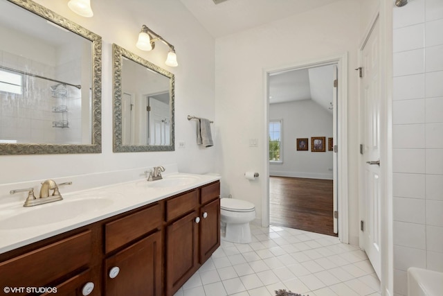 bathroom featuring tile patterned flooring, double vanity, toilet, and a sink