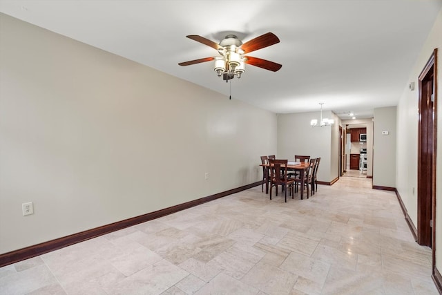 dining area featuring ceiling fan with notable chandelier and baseboards