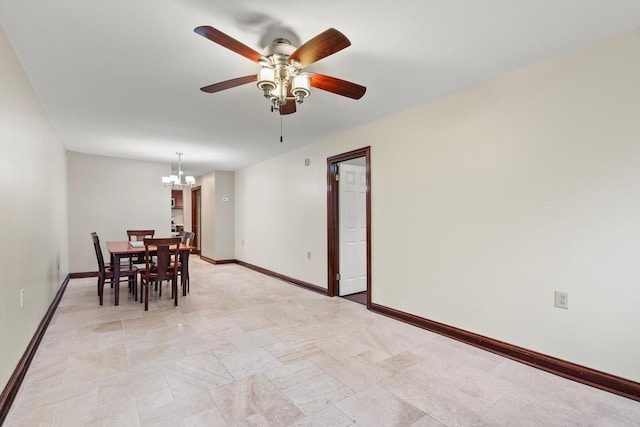 dining room featuring baseboards and ceiling fan with notable chandelier