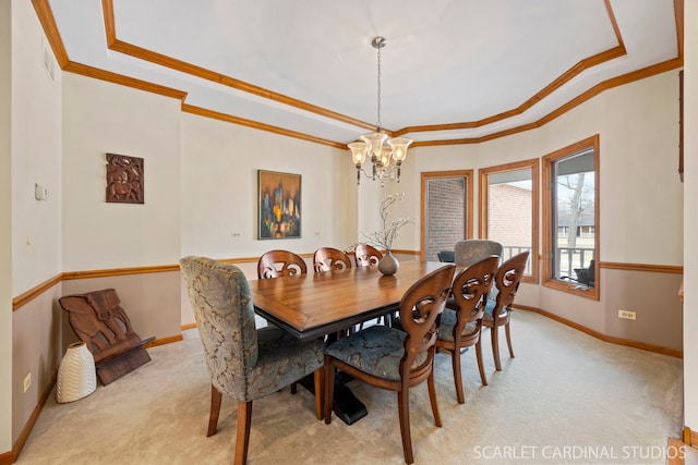 dining area with a notable chandelier, light colored carpet, a tray ceiling, and ornamental molding