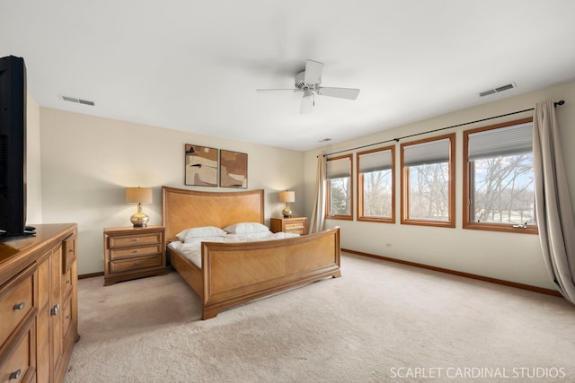 bedroom featuring multiple windows, baseboards, visible vents, and light carpet