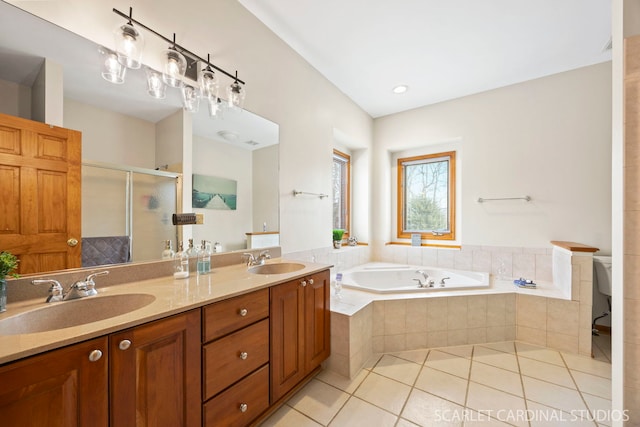 bathroom with tile patterned floors, a bath, a stall shower, and a sink