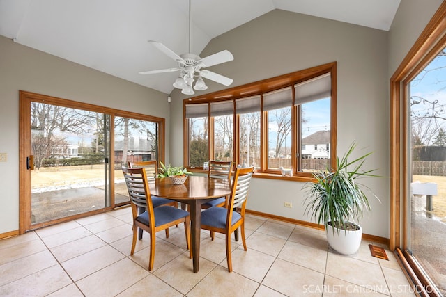 dining space featuring light tile patterned floors, baseboards, a healthy amount of sunlight, and vaulted ceiling