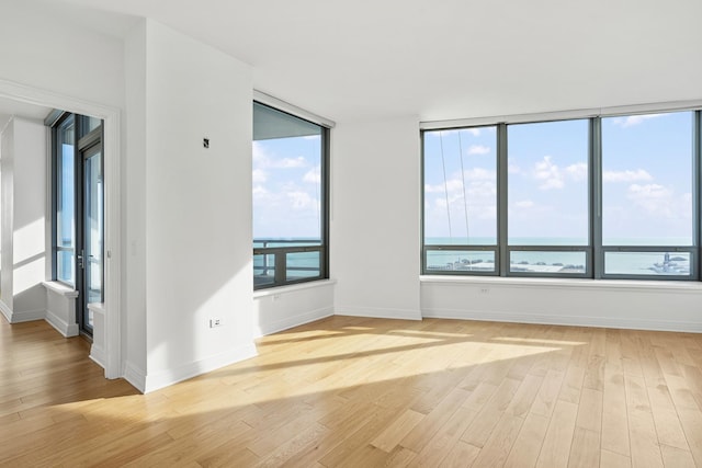 empty room with light wood-type flooring and baseboards