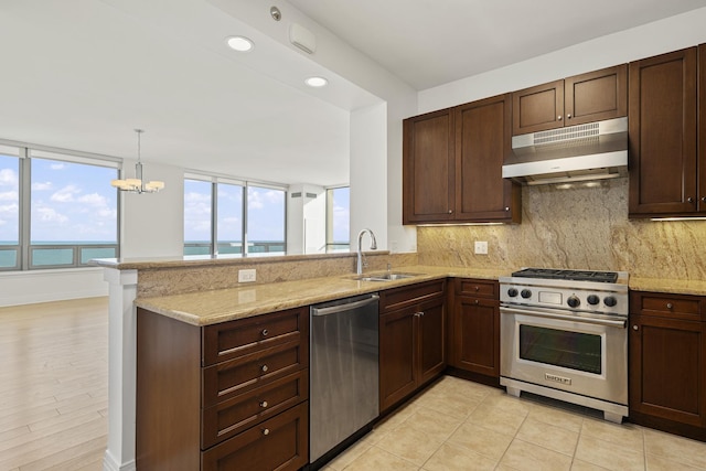 kitchen featuring a peninsula, a sink, stainless steel appliances, under cabinet range hood, and tasteful backsplash