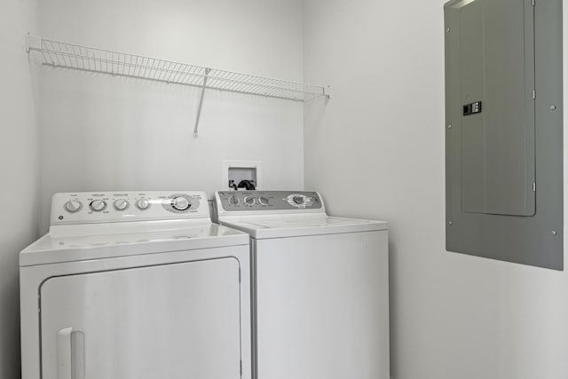 clothes washing area with electric panel, laundry area, and washer and dryer