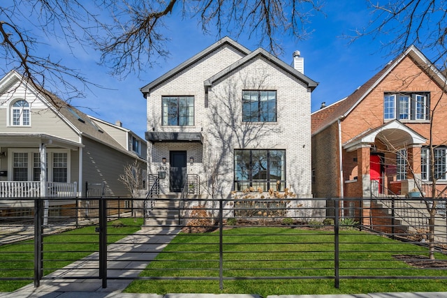 view of front of property featuring a front yard, brick siding, a fenced front yard, and a chimney