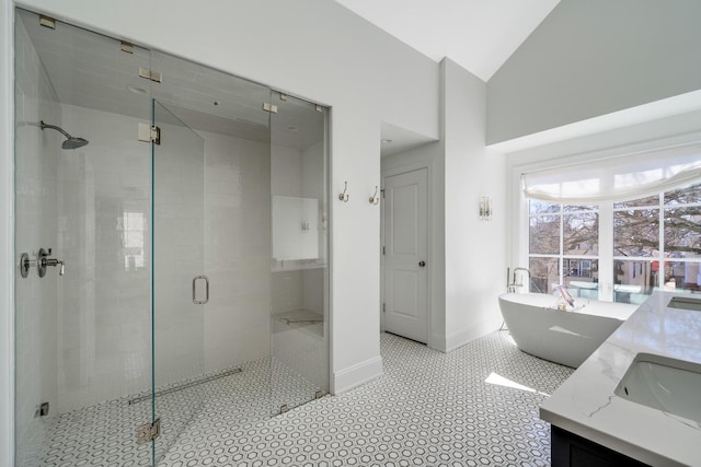 full bath with a shower stall, baseboards, vanity, a freestanding tub, and high vaulted ceiling