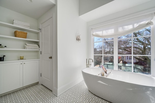 bathroom with baseboards and a soaking tub