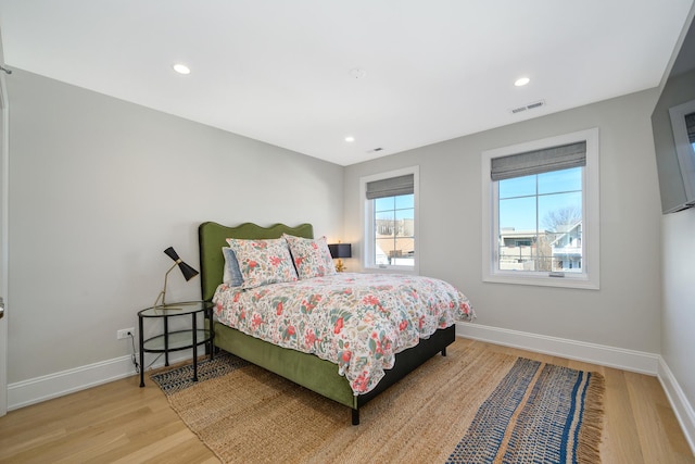 bedroom featuring visible vents, baseboards, and wood finished floors