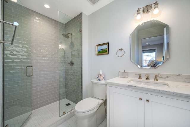 full bathroom featuring vanity, toilet, visible vents, and a stall shower