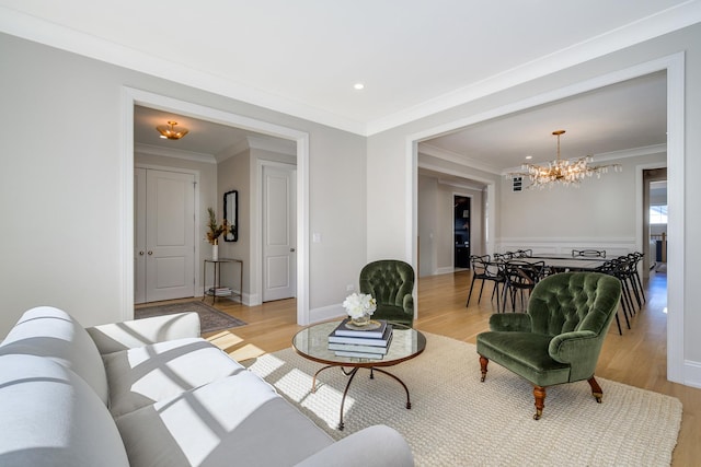 living area with recessed lighting, crown molding, light wood finished floors, baseboards, and a chandelier