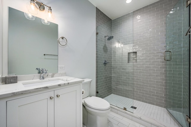 bathroom with tile patterned floors, toilet, a stall shower, and vanity