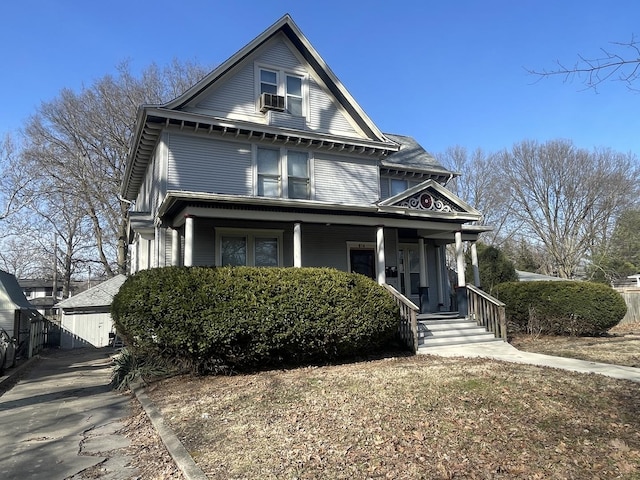 view of front of house featuring an outbuilding, covered porch, and cooling unit