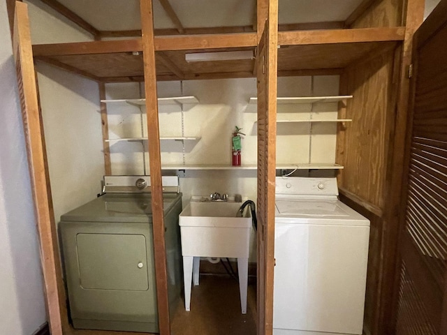 clothes washing area with laundry area, washer and dryer, and a sink