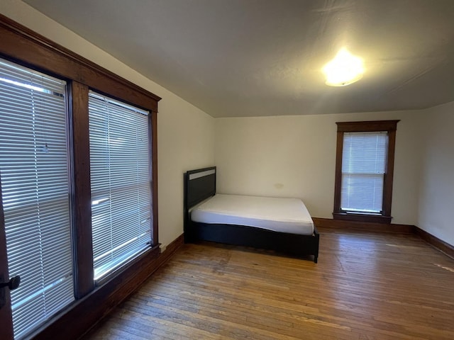 unfurnished bedroom with hardwood / wood-style flooring and baseboards