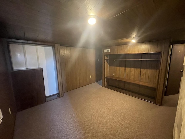 bonus room with wooden walls, visible vents, and carpet floors