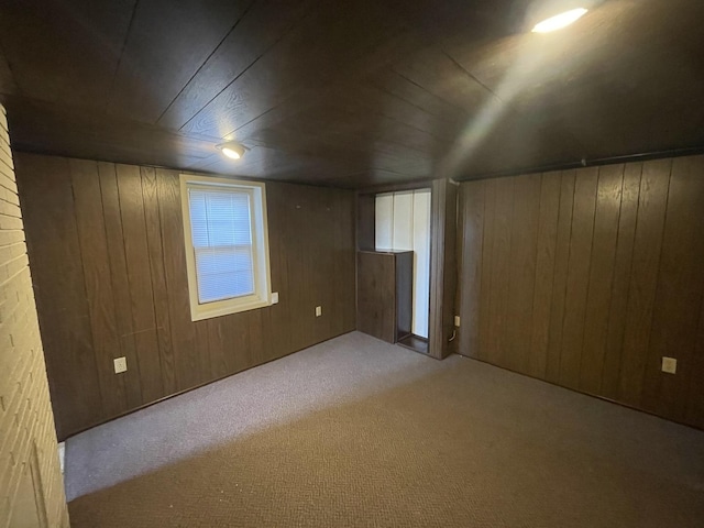 additional living space with wooden ceiling, wood walls, and carpet flooring