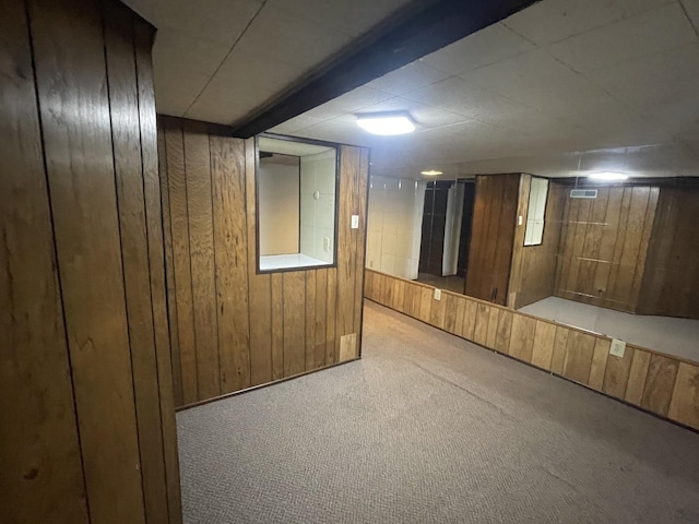 finished basement featuring carpet floors and wooden walls