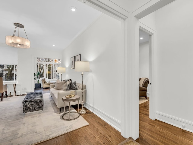 living room with lofted ceiling, recessed lighting, wood finished floors, and baseboards