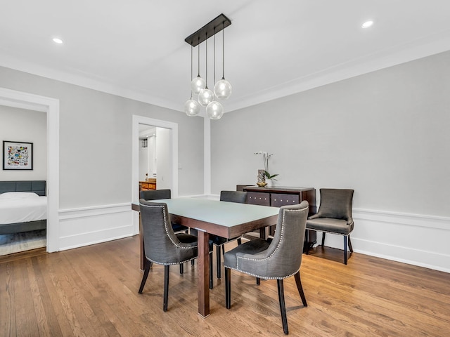 dining space featuring recessed lighting, wainscoting, crown molding, and wood finished floors