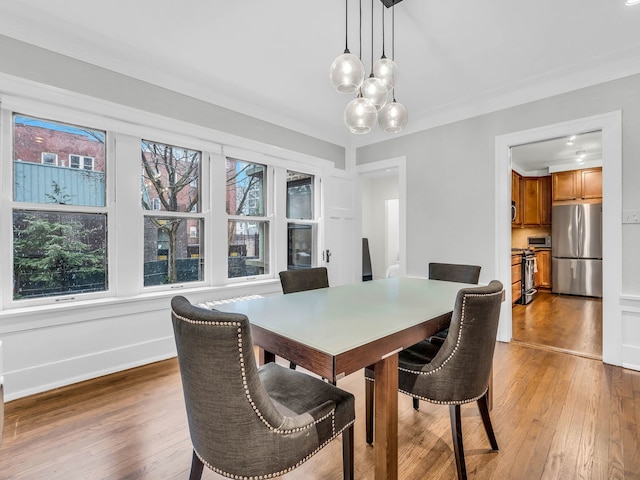 dining room with hardwood / wood-style flooring, baseboards, a wealth of natural light, and a chandelier