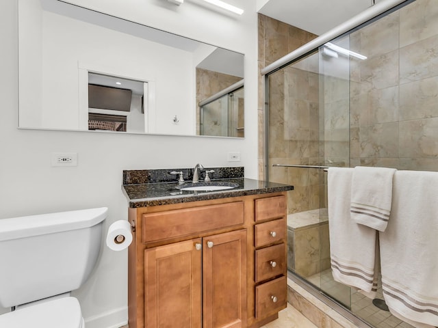 bathroom featuring a shower stall, toilet, and vanity