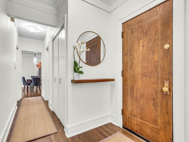 foyer featuring crown molding, wood finished floors, and baseboards