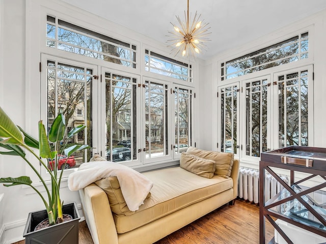 sunroom with plenty of natural light, radiator heating unit, and a chandelier