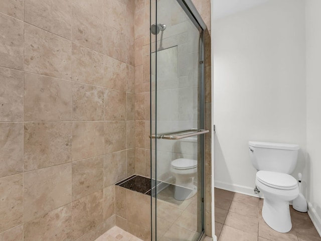 bathroom with tile patterned floors, baseboards, toilet, and a stall shower