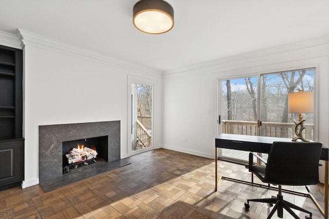 office space featuring baseboards, crown molding, and a premium fireplace