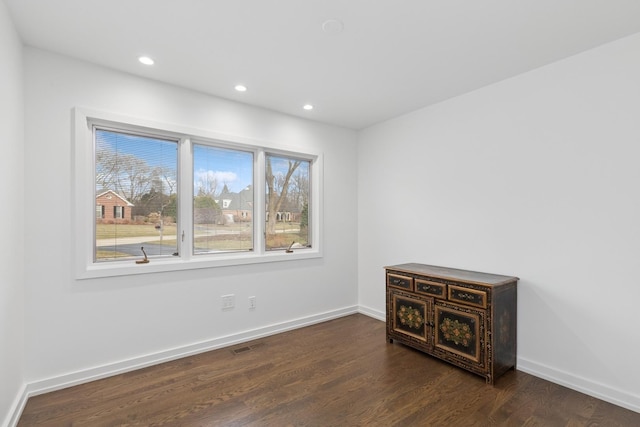 spare room with dark wood-style floors, visible vents, recessed lighting, and baseboards