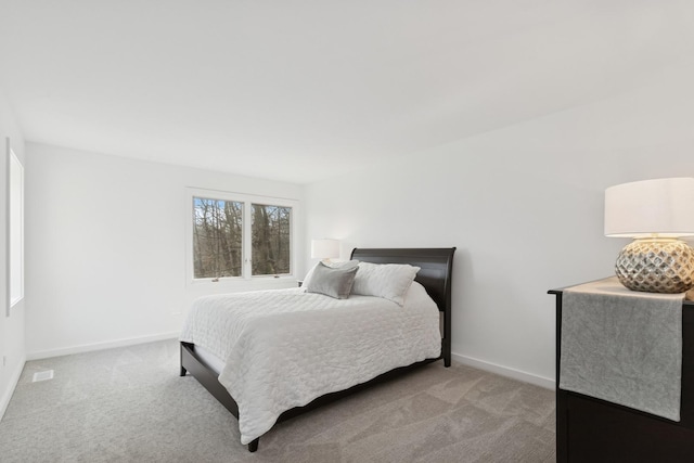 bedroom featuring baseboards, light colored carpet, and visible vents