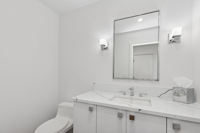bathroom featuring toilet and vanity