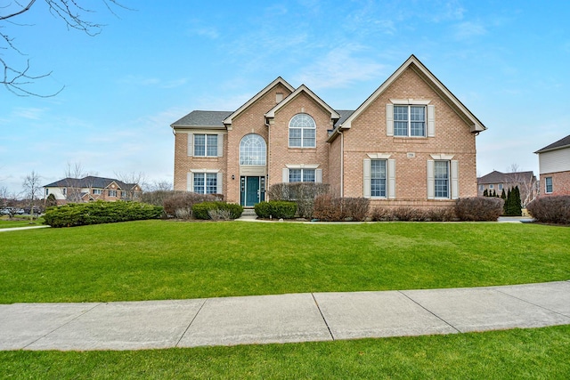 view of front of property featuring brick siding and a front lawn