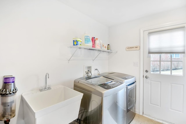 laundry room with laundry area, independent washer and dryer, and a sink