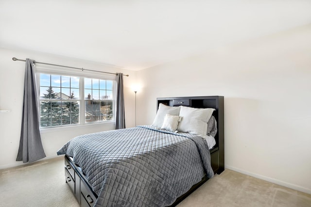 bedroom with light colored carpet and baseboards