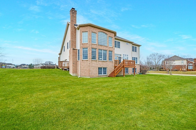 back of house with brick siding, stairway, a lawn, and a chimney