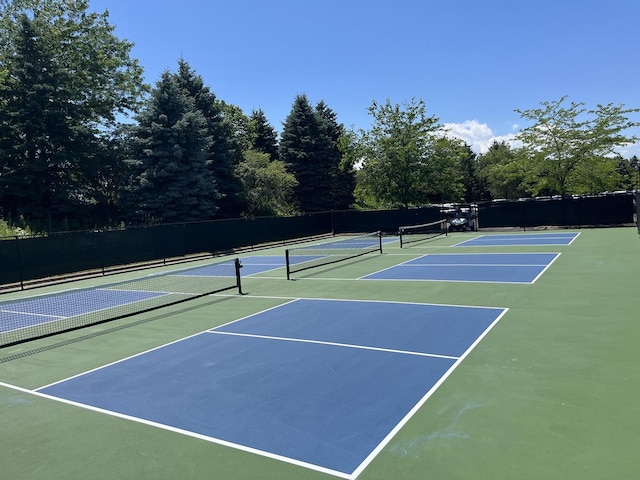 view of tennis court with community basketball court and fence