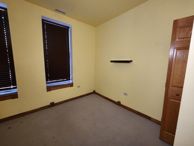 carpeted empty room featuring baseboards