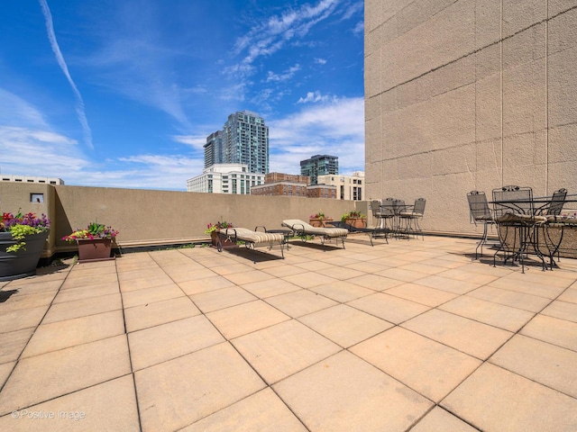 view of patio featuring a view of city and outdoor dining area