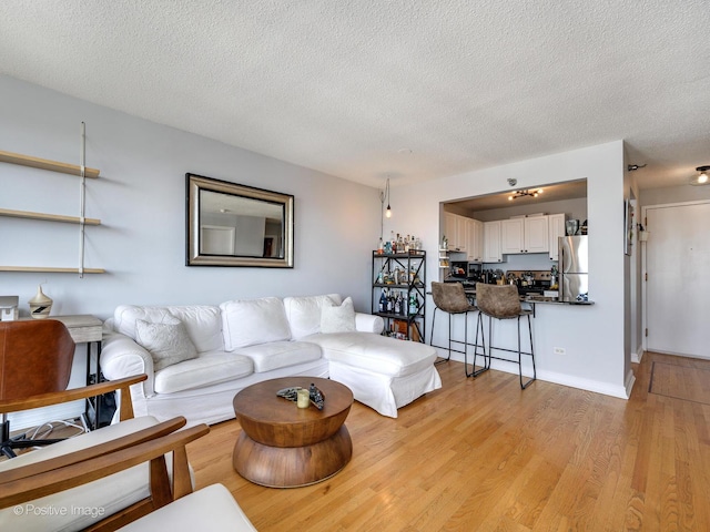 living area featuring light wood finished floors and a textured ceiling