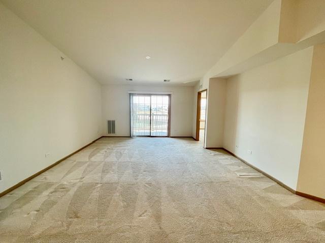 unfurnished room with light carpet, visible vents, and baseboards