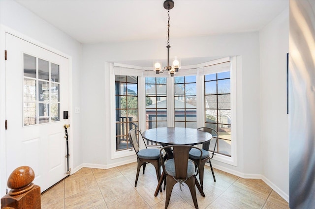 dining area with a chandelier, light tile patterned floors, and baseboards