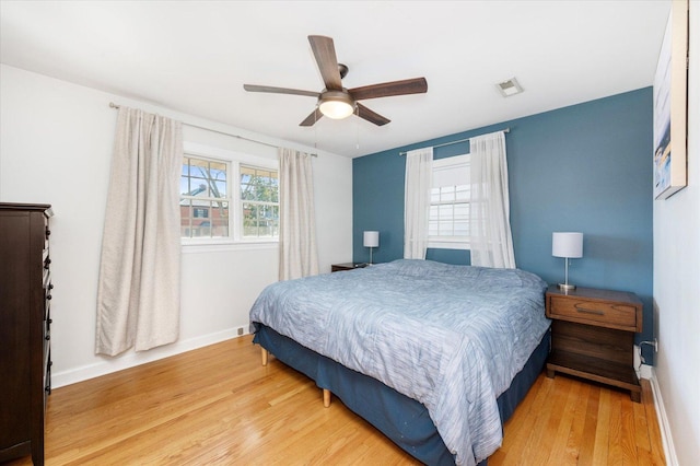 bedroom with visible vents, ceiling fan, baseboards, and wood finished floors