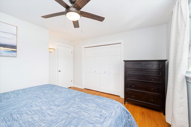 bedroom with a ceiling fan, light wood-style floors, and a closet