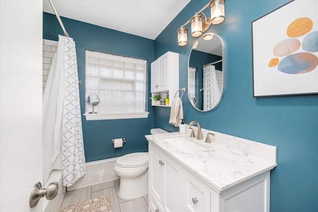 bathroom with curtained shower, baseboards, toilet, and vanity