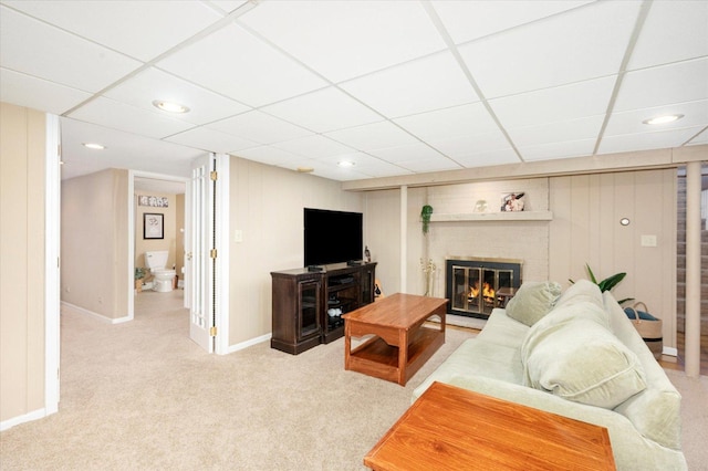 carpeted living area featuring recessed lighting, baseboards, a paneled ceiling, and a fireplace